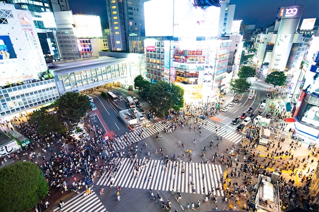 Eine Vogelperspektive auf die Menschenmengen, die die durcheinandergebrachte Kreuzung in Shibuya (Tokio, Japan) überqueren.