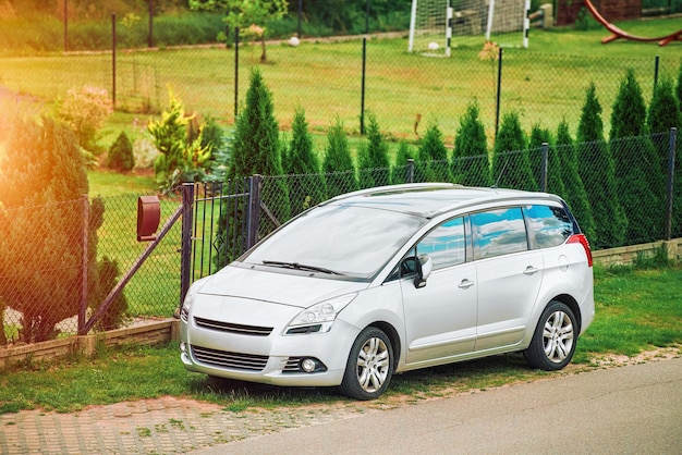 Foto eine vorderseite des silbernen minivans geparktes fahrzeug an der landstraße elegantes europäisches suv in ländlicher umgebung geparkt