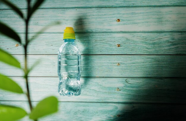 Eine Wasserflasche auf einem hölzernen Hintergrund. trinke mehr wasser und wärme