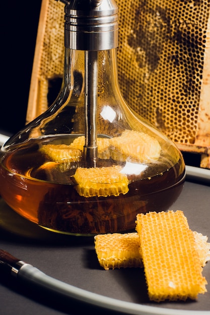 Eine Wasserpfeife auf Honigbasis, ein süßer Wasserpfeifengeschmack neben Wabenwaben