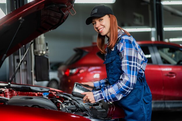 Foto eine weiße automechanikerin benutzt einen speziellen computer, um fehler zu diagnostizieren