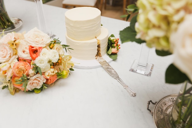 Eine weiße Hochzeitstorte mit einem Blumenarrangement darauf
