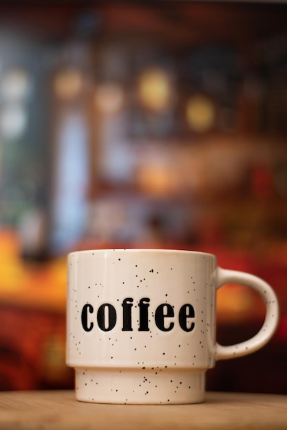 Eine weiße Kaffeetasse mit dem Wort Kaffee darauf