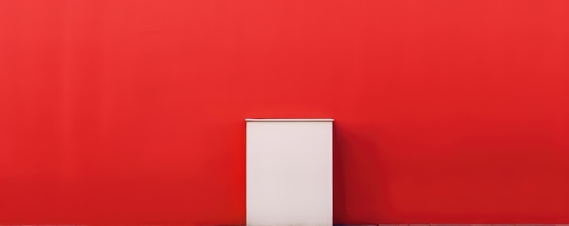Eine weiße Kiste vor einer roten Wand steht vor einer roten Wand.
