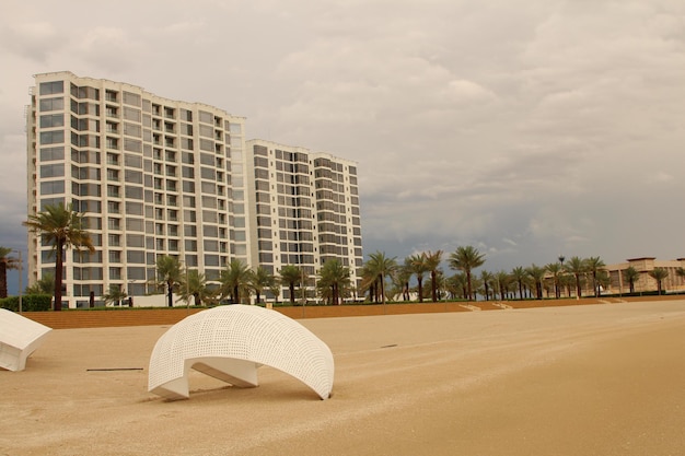 eine weiße Skulptur am Strand mit einem Palmbaum im Hintergrund