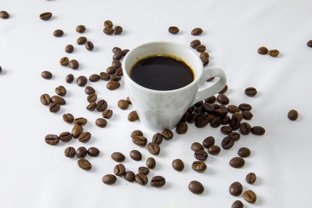 Eine weiße Tasse Kaffee auf weißem Hintergrund mit Kaffeebohnen