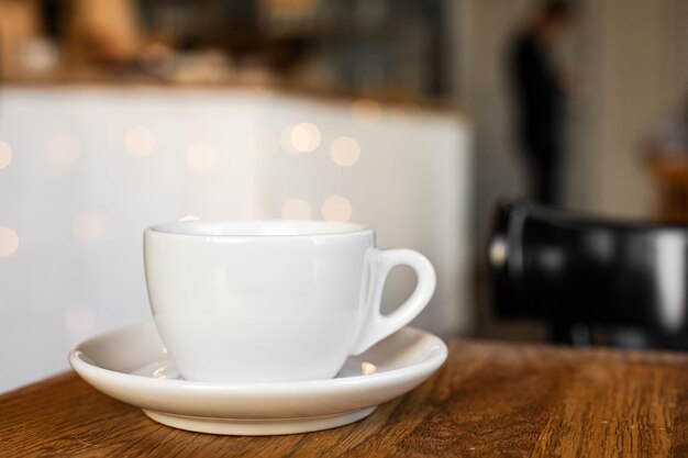 Foto eine weiße tasse schwarzes kaffee auf einer schüssel auf dem holztisch in einem café