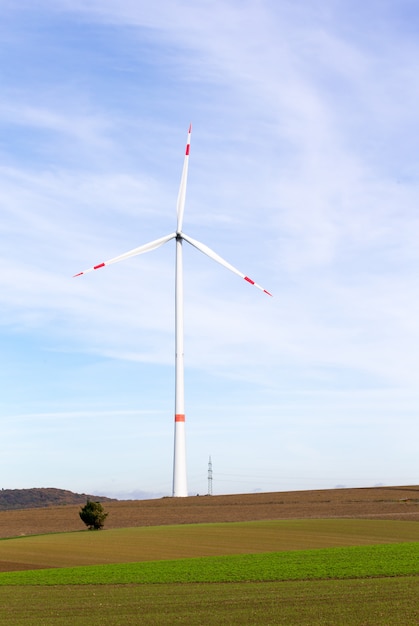 Eine Windmühle auf einem Feld mit blauem Himmel