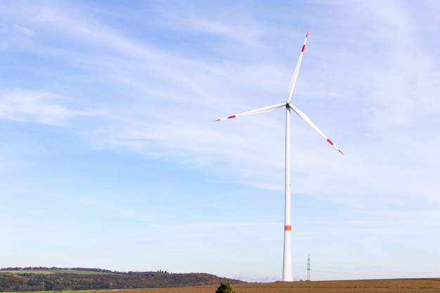 Eine Windmühle auf einem Feld mit blauem Himmel