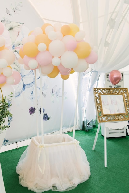 Eine wunderschön geschmückte Party mit Luftballons in einem großen weißen Zelt mit Fotozonen-Catering und Candybar