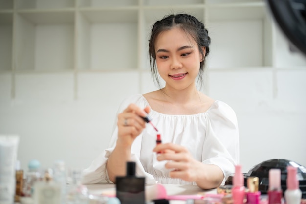 Eine wunderschöne asiatische Beauty-Bloggerin und Influencer probiert einen neuen Lippenstift aus