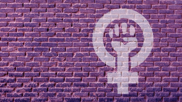 Foto eine zeichnung einer starken faust, die mit weiblichem geschlecht erhoben wurde, mit kopienraum für ihren werbetext oder ihre werbung auf der lila ziegelwand. feminismus-symbol-girl-power-konzept.