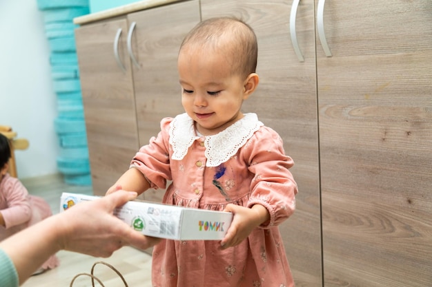 Einem Baby wird eine Schachtel Bio-Milch überreicht.
