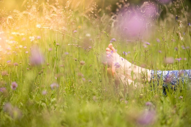 Einen Sommertag genießen Junges Mädchen mit Yogahose liegt im grünen Gras