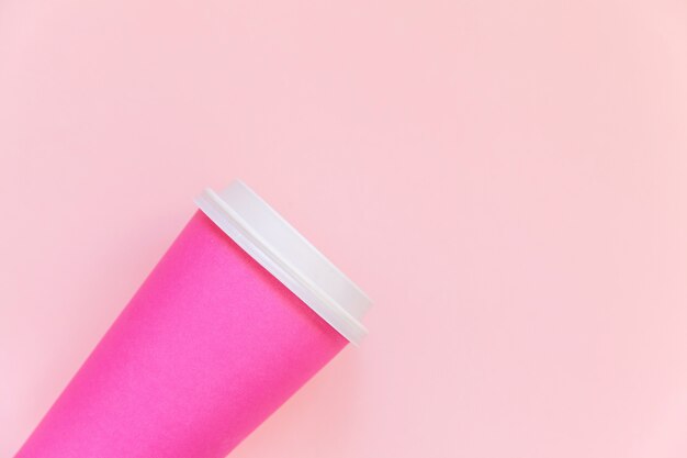 Einfach flach legen Sie Designrosapapierkaffeetasse auf rosa buntem modischem Pastellhintergrund