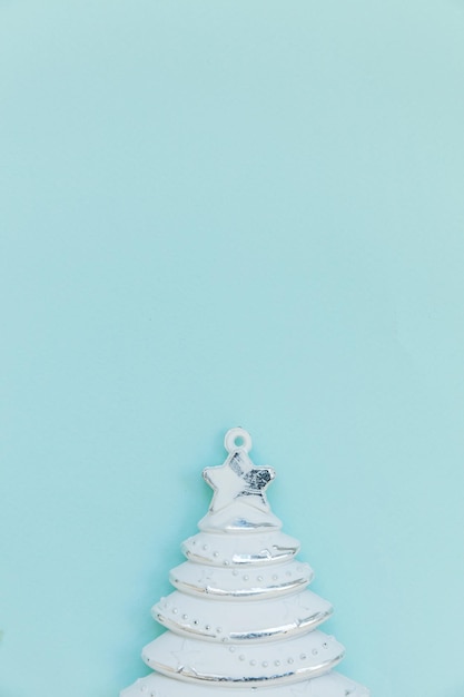 Einfach minimale Komposition Winterobjekt Ornament Tannenbaum isoliert auf blauem pastellfarbenem trendigem Hintergrund. Weihnachten Neujahr Dezember Zeit für Feierkonzept. Flache Draufsicht Kopienraum