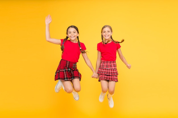 Einfach nur im englischen Stil sein Mode glückliche kleine Mädchen im karierten Rock Schönheit schauen glückliche Kinder Kindheit Glück trendige Schuluniform lustig springen rote Mode Mädchen