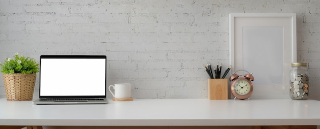 einfacher Arbeitsbereich mit Laptop, Briefpapier, Dekorationen und Kopierraum