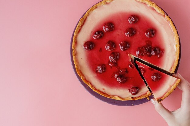 Einfacher Käsekuchen mit Kirschgelee auf Teller. Nahaufnahme mit Kopierraum