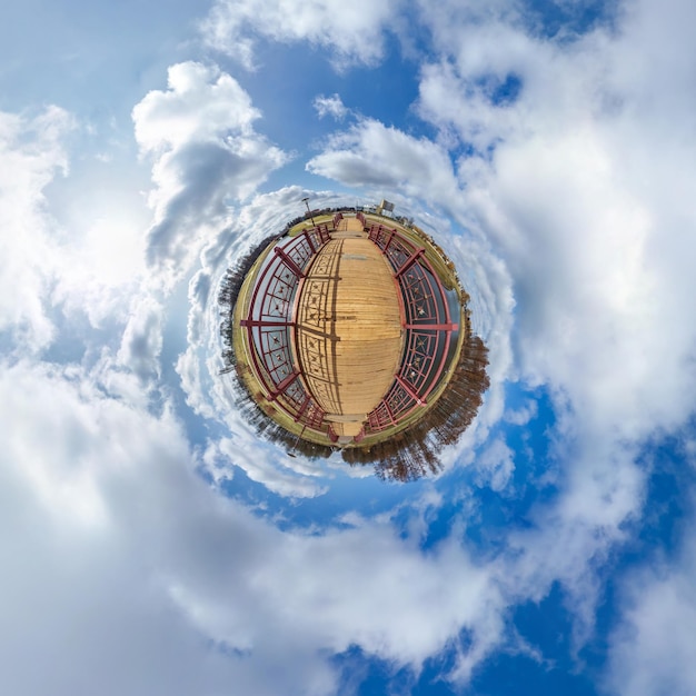 Einfacher winziger grüner Planet ohne Gebäude am blauen Himmel mit wunderschönen Wolken Transformation des sphärischen Panoramas 360 Grad sphärische abstrakte Luftansicht Krümmung des Raumes