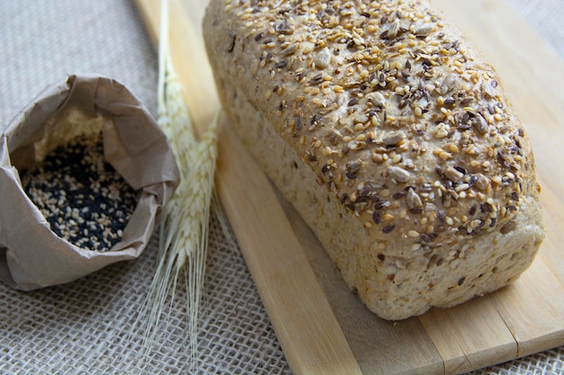 Einfaches Brot mit Bestandteilen über hölzernem Hintergrund Beschneidungspfad eingeschlossen