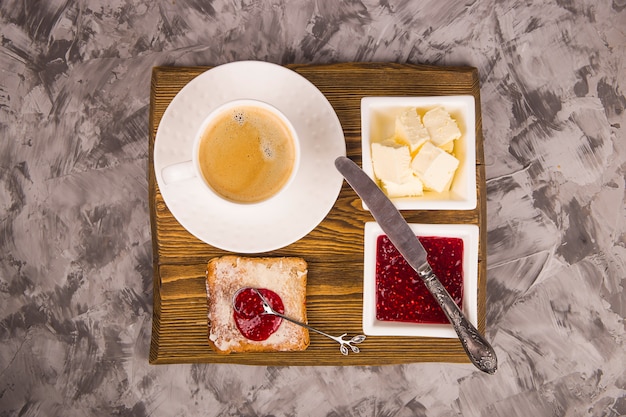 Einfaches frühstück mit traditionellen produkten - toast mit butter und himbeermarmelade