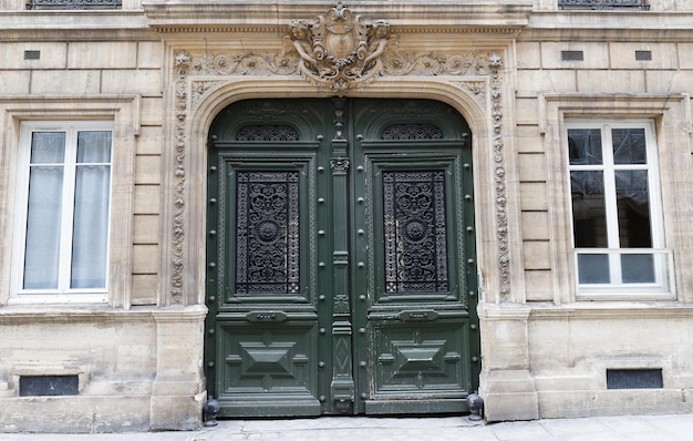 Eingang der klassischen Architektur mit grün lackierter Tür und goldenen Platten an den Türverkleidungen Fassade des Hauses in Paris Frankreich
