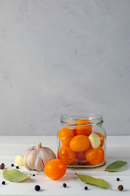 Eingelegte gelbe Kirschtomaten in einem Glas mit Gewürzen Pfeffer