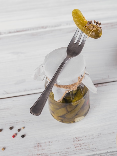 Eingelegte Gurken, Gewürze und Knoblauch auf einem weißen Holztisch konservieren. Gesundes fermentiertes Essen. Hausgemachtes Gemüse aus der Dose.