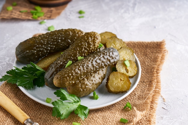 Eingelegte Gurken mit Kräutern und Zwiebeln in einem Teller auf dem Tisch Probiotika Essen