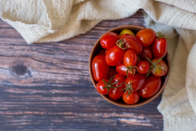 Eingelegte Kirschtomaten in Tonplatte auf Draufsicht des hölzernen Hintergrundes