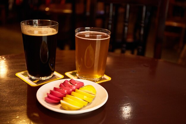 Eingelegte marinierte Eier rosa und gelb auf einem weißen Teller und einem Glas Bier im Pub