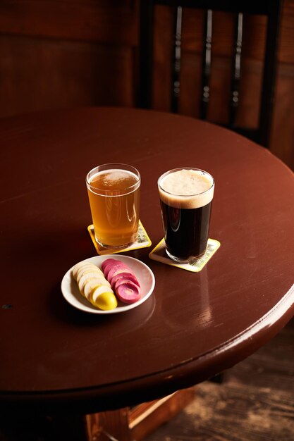 Eingelegte marinierte Eier rosa und gelb auf einem weißen Teller und einem Glas Bier in der Kneipe