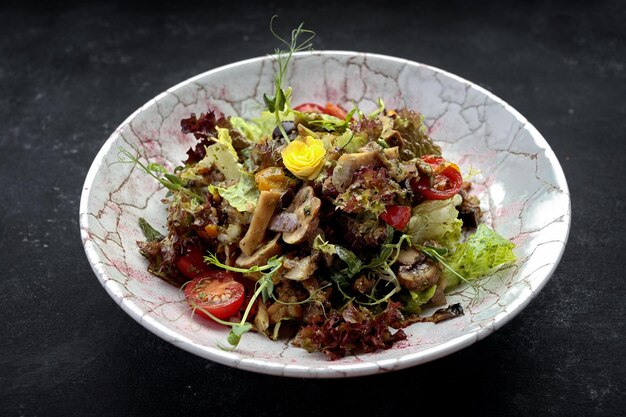 Eingelegte Pilze auf einem Teller mit Salat und Tomaten