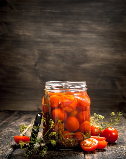 Eingelegte Tomaten mit Kräutern und Gewürzen im Glas.