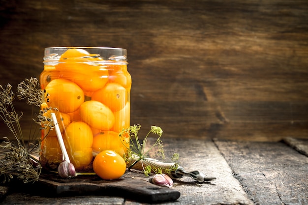 Eingelegte Tomaten mit Kräutern und Gewürzen im Glas.