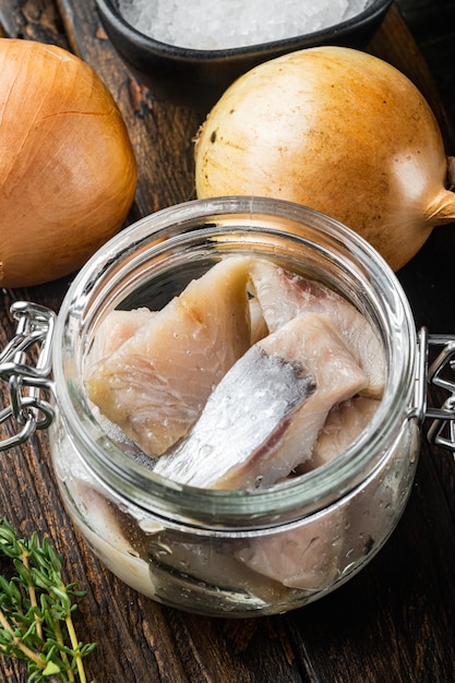 Eingelegter Hering in Öl auf einem alten dunklen Holztisch