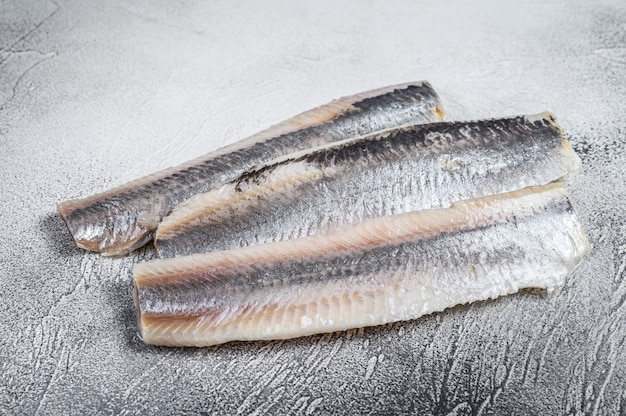 Foto eingelegtes mariniertes seeheringsfilet auf weißem tisch. draufsicht.