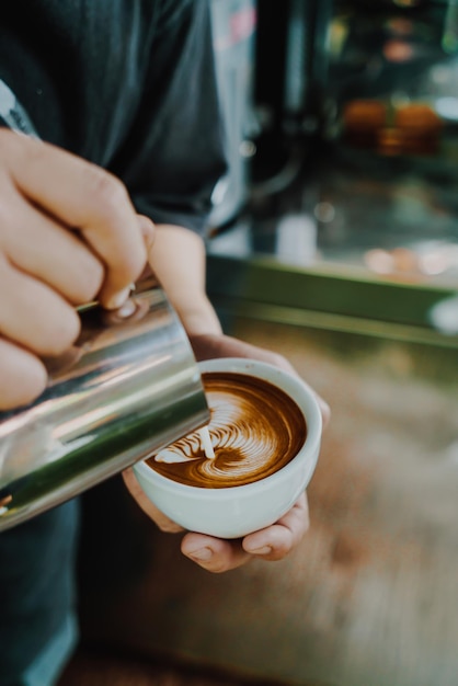 Eingießen von Milch für die Zubereitung von Latte Art Kaffee