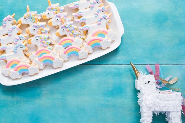 Foto einhorn-zuckerplätzchen verziert mit königlicher zuckerglasur auf blauem hintergrund.