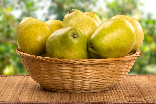 Einige Birnen in einem Korb über einer Holzoberfläche. Frische Früchte