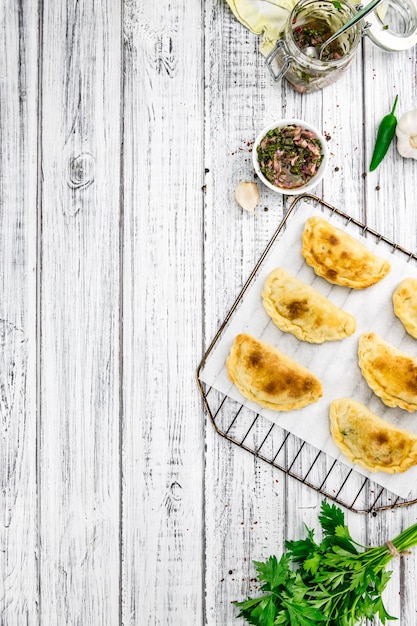 Einige Empanadas auf einem Vintage-Holztisch mit selektivem Fokus, Nahaufnahme