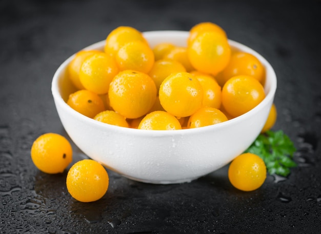 Einige gelbe Tomaten auf einer dunklen Schieferplatte