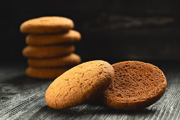 Einige Hafermehlplätzchen auf dunklem hölzernem Schreibtisch. Bäckereiprodukte