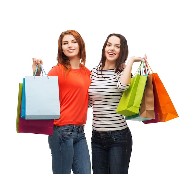 Einkaufs-, Verkaufs- und Geschenkkonzept - zwei lächelnde Mädchen im Teenageralter mit Einkaufstüten