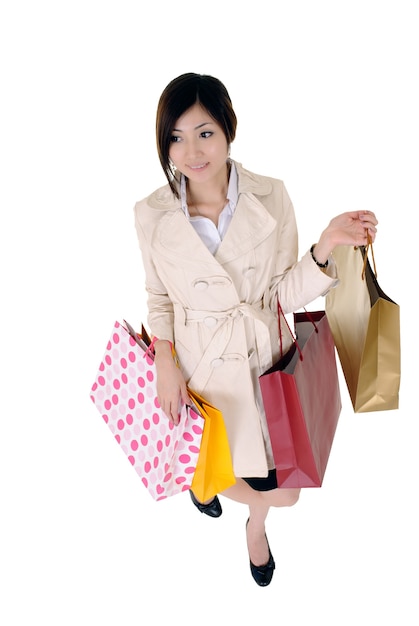 Einkaufsfrau lächelt und hält bunte Taschen.