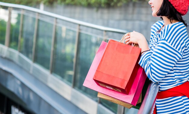 Einkaufsgeschenk und Geschenk im Urlaub für Neujahr und Geburtstagsfeier. Teenager-Frauen, die eine Einkaufstasche halten.