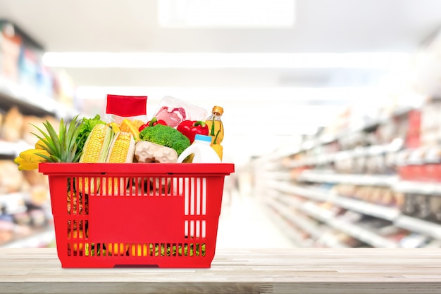 Foto einkaufskorb voll von lebensmitteln und lebensmittelgeschäften auf dem tisch im supermarkt