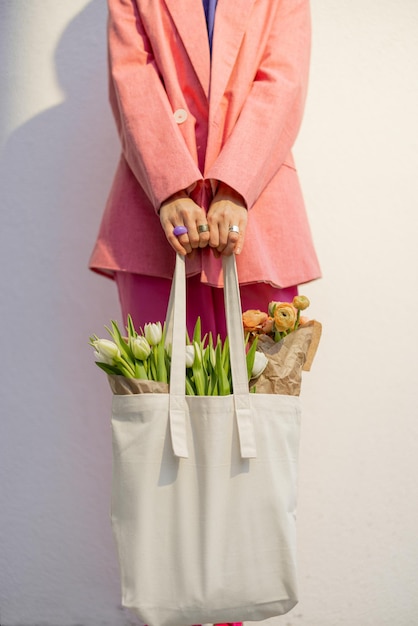 Einkaufstasche mit Blumen halten