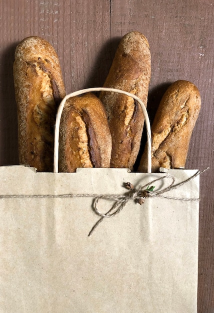 Einkaufstasche mit Brot auf dem hölzernen Hintergrund, Online-Lieferkonzept.